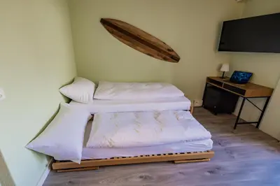 Ein Bett oder Betten in einem Zimmer der Unterkunft Surfers Oase near Interlaken at lake with pool