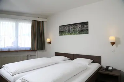 Ein Bett oder Betten in einem Zimmer der Unterkunft Hotel Crystal Interlaken