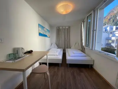Ein Bett oder Betten in einem Zimmer der Unterkunft Interlaken Linda Inn Lodge