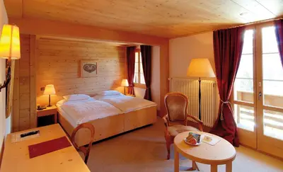 Ein Bett oder Betten in einem Zimmer der Unterkunft Hotel Alpenrose Wengen - a family affair since 1881