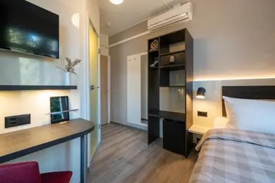 Ein Bett oder Betten in einem Zimmer der Unterkunft Hotel Derby Interlaken - self check-in